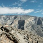 person sitting on rock mountain during daytime