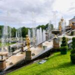 a fountain with statues and a building in the background